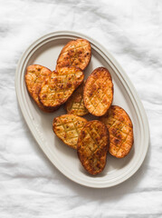Barbecue potatoes - delicious appetizer, tapas, lunch on a light background, top view