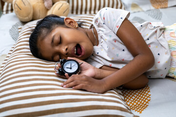 Sleeping girl holding a clock in a cozy bedroom setting