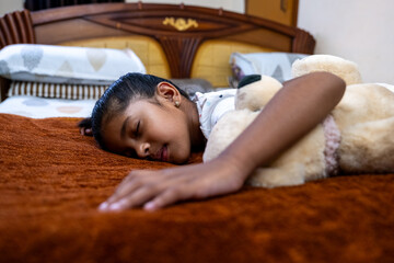Young girl peacefully sleeping with teddy bear in bedroom