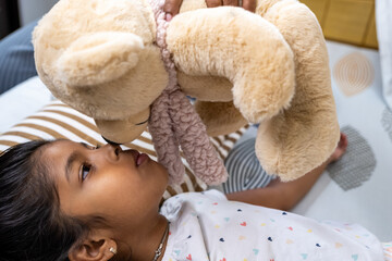 Young girl with teddy bear during playtime at home