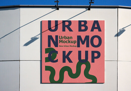 A blank white advertisement space on a building's wall captures direct sunlight, ready for urban advertising.