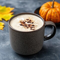 Warm Autumn Beverage in Dark Mug with Pumpkin and Leaves