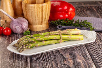 Raw green asparagus over board