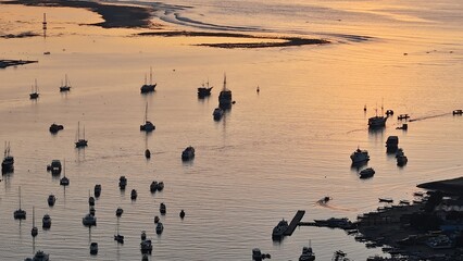 Early Morning Aerial of Coastal Bali with Reflections of Boats and Sky on the Water