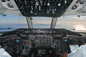 Pilots flying above the clouds in airplane cockpit