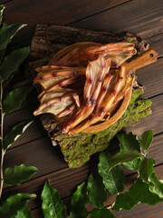 dry duck feet on wooden dark background. top view. snack for dogs