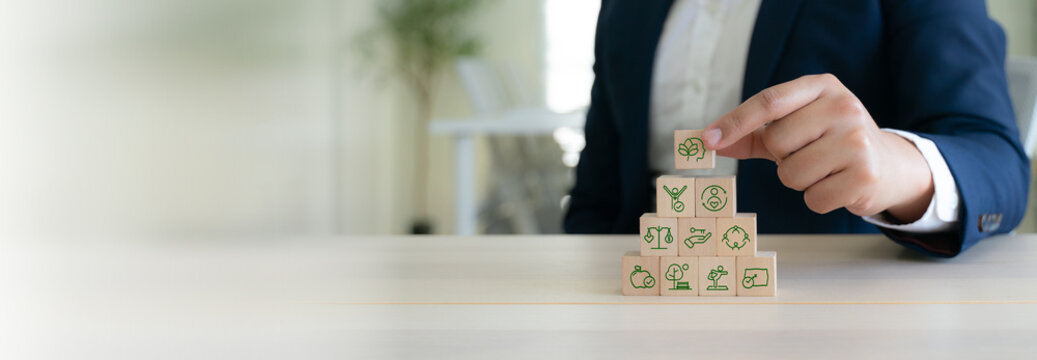 Corporate wellness strategy concept. Sustainable mental health and well-being at workplace. Wooden blocks with icons representing holistic wellness; balance, fitness, nature, relaxing and happiness.