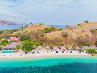 Luxury beach hotel swimming pool facing white sand beach and clear turquoise ocean. Idyllic summer...