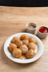 Cilok is a snack made from tapioca flour and served with savory and spicy peanut sauce. Perfect for recipes, articles or any cooking content.