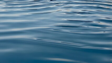 water surface ripples in soft blue tones. Light reflections shimmer across the fluid curves and concentric waves.