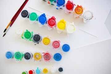 Paint brushes and paint cans on white paper