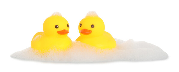 Cute rubber ducks and foam isolated on white