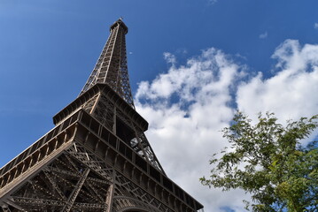Sublime cliché de la Tour Eiffel éclairée par la gauche, sous un beau ciel bleu.