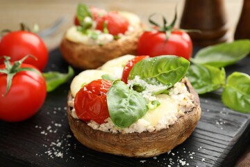 Tasty stuffed mushrooms served on wooden table, closeup