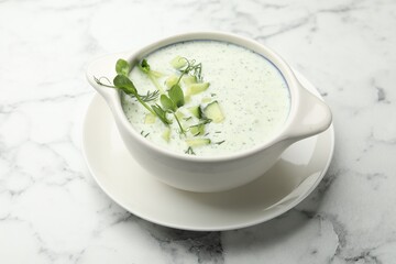 Tasty cucumber soup with dill and microgreens on white marble table, closeup