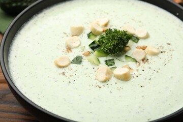 Tasty cucumber soup with croutons and broccoli on wooden table, closeup