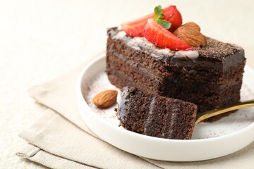 Piece of delicious chocolate cake with strawberry and almonds on table, closeup. Space for text