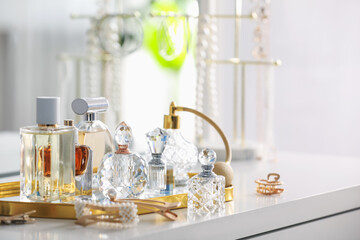 Bottles of different perfumes on white table indoors, space for text