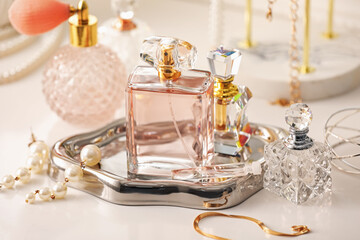 Bottles of different perfumes and accessories on dressing table indoors, closeup