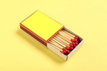 Matches in box on yellow background, closeup. Mockup for design
