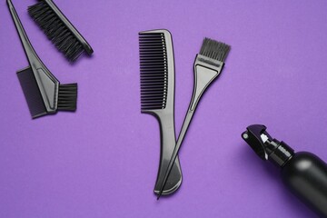 Different hairdresser's tools on purple background, flat lay