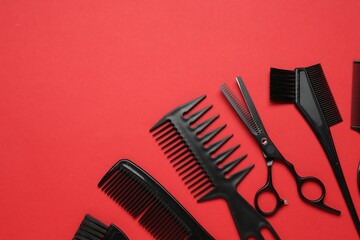 Different hairdresser's tools on red background, flat lay. Space for text