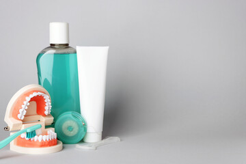 Different oral care products on light grey background, space for text