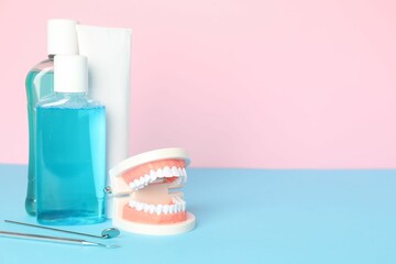 Different oral care products and dental model on color background. Space for text