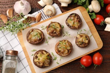 Delicious stuffed mushrooms and products on wooden table, flat lay
