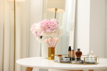Tray with different makeup products on white table indoors