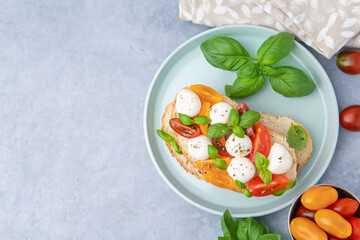 Tasty sandwich with mozzarella cheese, tomatoes and basil on grey table, flat lay. Space for text