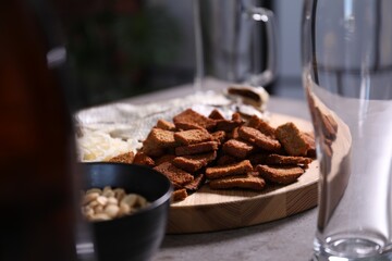 Empty beer glasses and snacks on grey table indoors, closeup