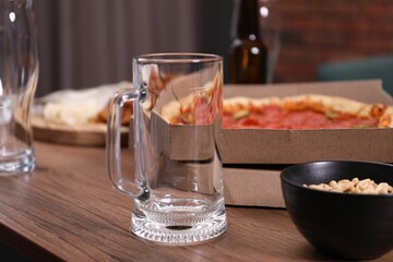 Empty beer glasses and snacks on wooden table indoors, closeup