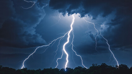 Stunning spectacular view of lightning strikes illuminating a dark and stormy sky above trees