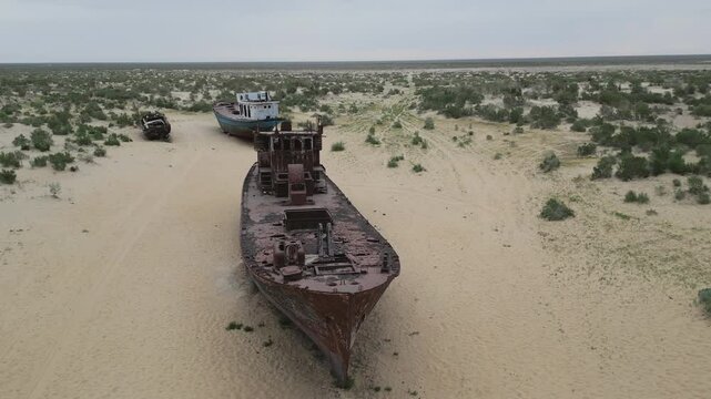 Old vessels stranded in desert with Muynak settlement nearby