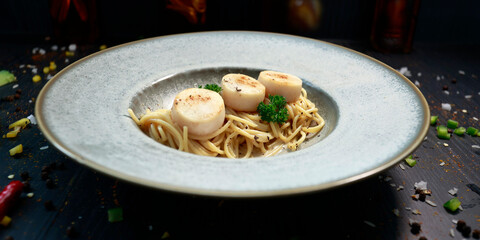 close up of a plate of pasta with scallops inside