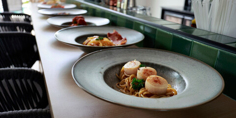 close up of alignment of plates on a counter  with pasta inside