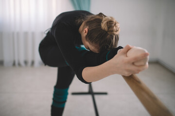 Female ballet dancer stretching on barre