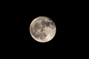 Full moon close up with craters and detail in a black sky
