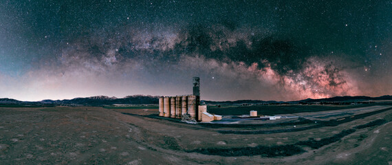 Grain silo at night under the full Milky Way arch - panorama