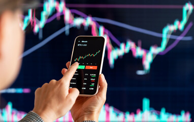Female digital investor analyzing cryptocurrency trends on smartphone.