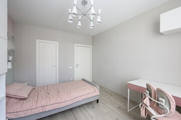 clean, modern bedroom with a pink and gray color scheme. Features a bed, desk, and stylish lighting