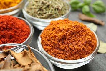 Different aromatic spices on grey table, closeup