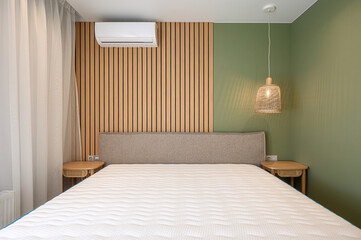 bright bedroom features a white bed, large white wardrobe, sheer curtains over a window, a wooden...