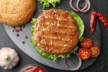 Delicious hamburger with patty served on black table, flat lay