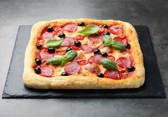 Tasty homemade pizza with basil on grey table
