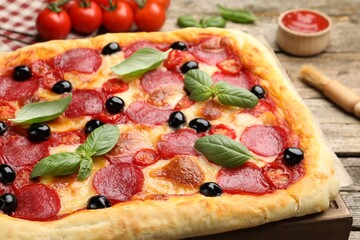 Tasty homemade pizza and ingredients on wooden table, closeup