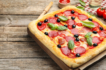 Tasty homemade pizza and ingredients on wooden table, closeup