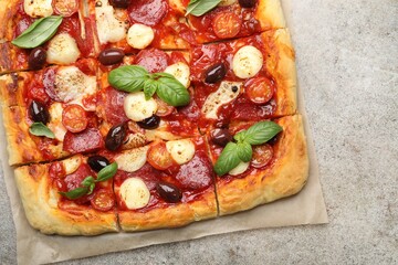 Tasty square homemade pizza on grey table, top view