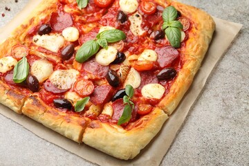 Tasty square homemade pizza on grey table, closeup